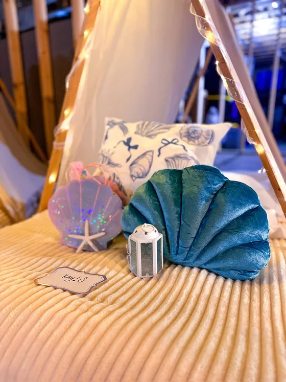 Coastal Camp sleepover setup: Shells, lanterns and soft sand tones.