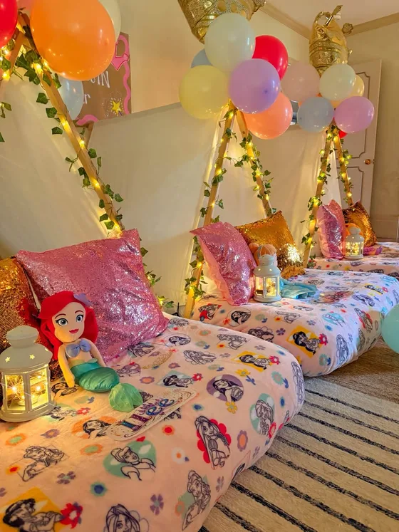 Disney Princess sleepover setup: Twinkling lanterns, castle vines and a tiara on every bed.