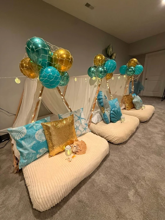 Seaside Dreams sleepover setup: Seashell pillows, gold sequins and a glowing lantern.