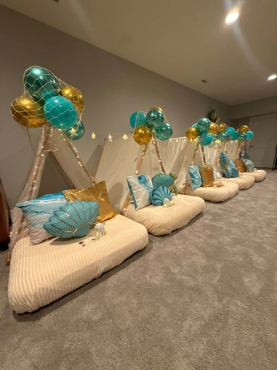 Seaside Dreams sleepover setup: A clamshell pillow under a net of teal and gold.