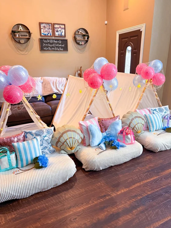 The Summer I Turned Pretty sleepover setup: Shell pillows and pink and blue balloons down the whole row.