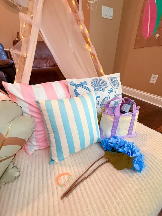 The Summer I Turned Pretty sleepover setup: Pink and blue stripes, shells and a beaded bracelet.