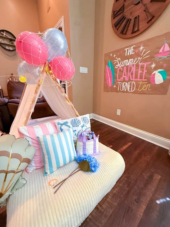 The Summer I Turned Pretty sleepover setup: Surfboards, sailboats and a beach ball on the sign.
